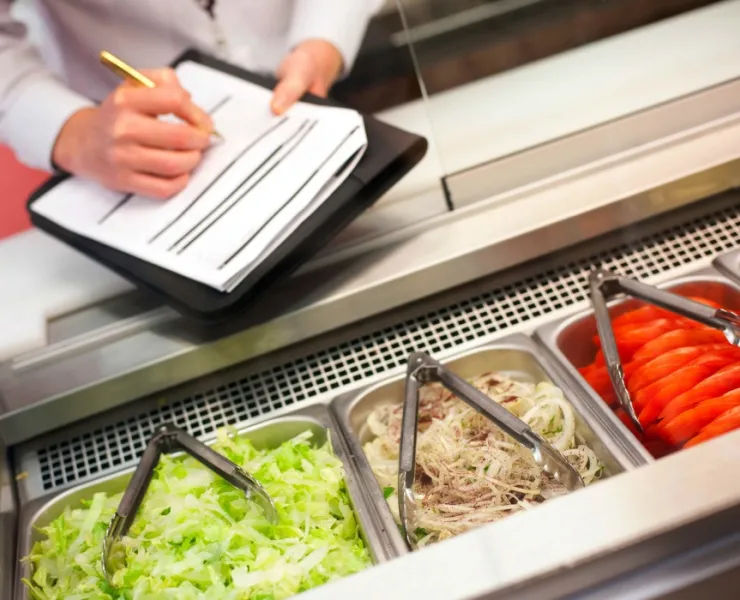 Food safety inspector inspecting food preparation